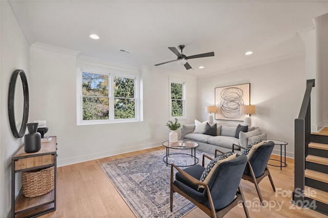 living room with light hardwood / wood-style flooring, ceiling fan, and crown molding