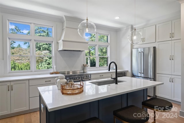 2023 Thurmond Pl Unit 14, Charlotte, NC 28205 - kitchen with high end appliances, custom exhaust hood, light countertops, a breakfast bar, and light wood finished floors