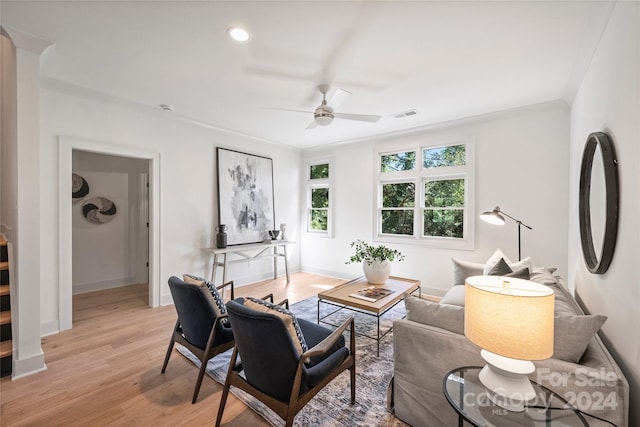 living room with ceiling fan, light hardwood / wood-style flooring, and crown molding