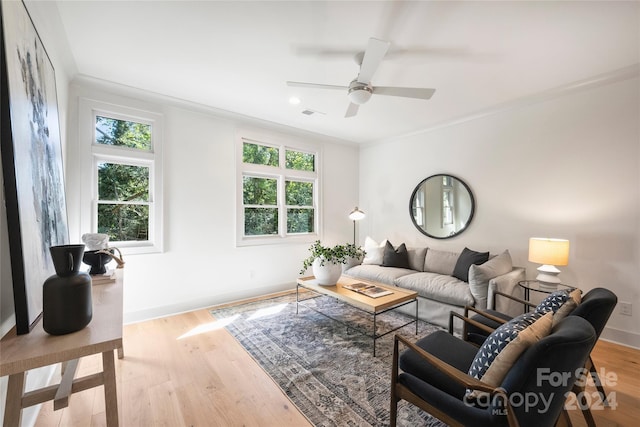 living room featuring crown molding, ceiling fan, and light hardwood / wood-style floors