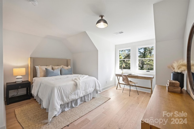 bedroom featuring light wood-type flooring and vaulted ceiling