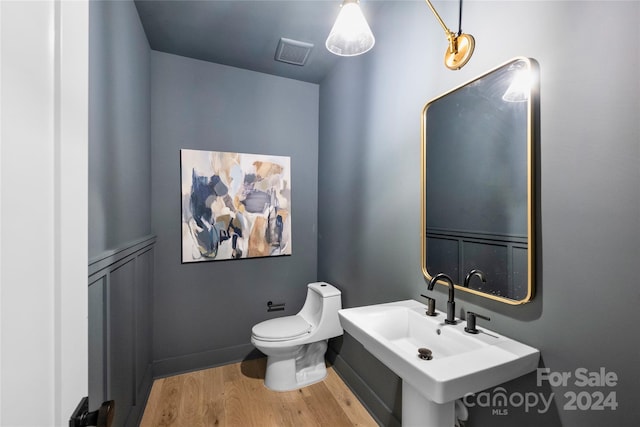 bathroom with hardwood / wood-style floors, toilet, and sink