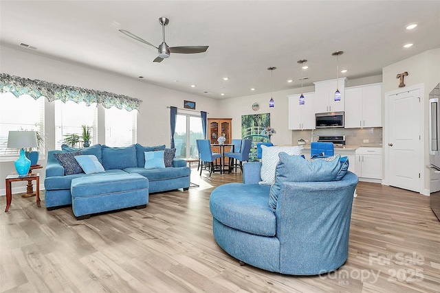 living room featuring ceiling fan and light hardwood / wood-style floors