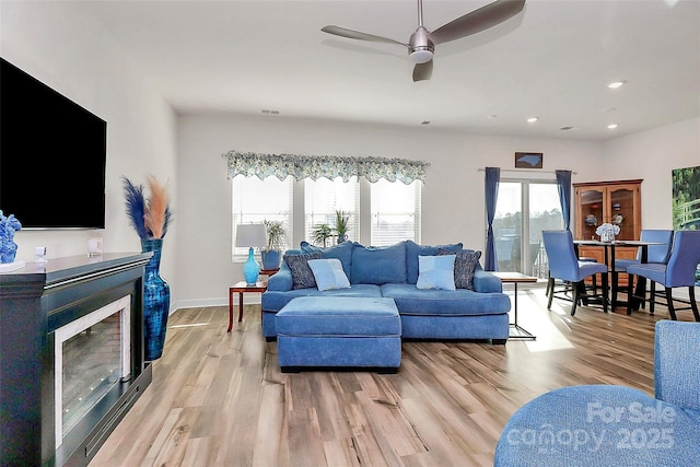 living room with ceiling fan and light hardwood / wood-style floors