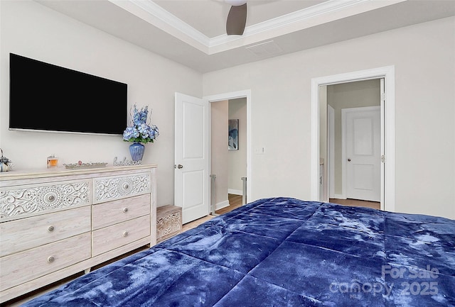 bedroom with ceiling fan, ornamental molding, and a tray ceiling