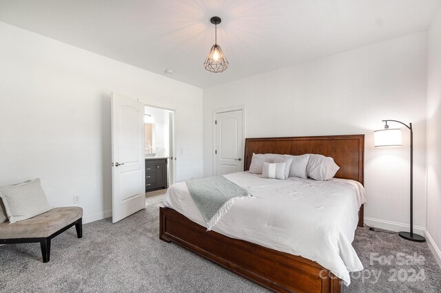 carpeted bedroom featuring ensuite bath