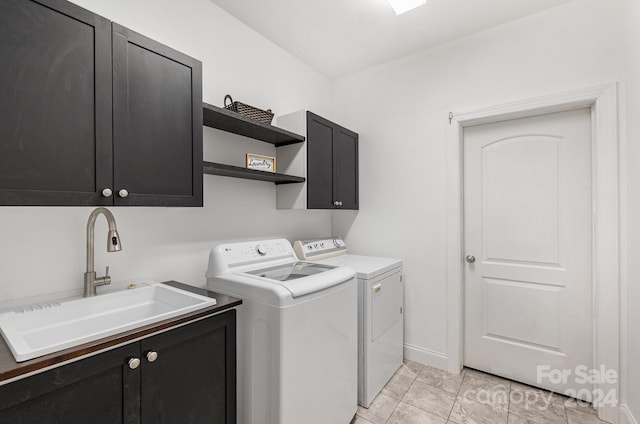 laundry room featuring cabinets, separate washer and dryer, and sink