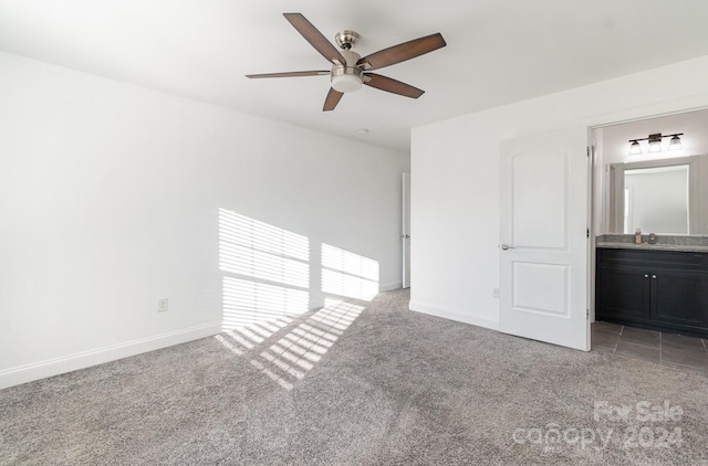 unfurnished bedroom with connected bathroom, light colored carpet, and ceiling fan