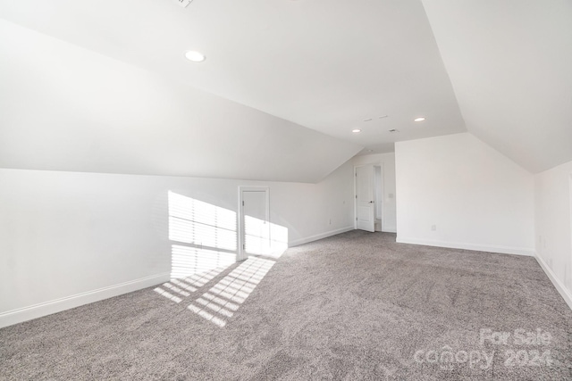 bonus room featuring carpet floors and vaulted ceiling