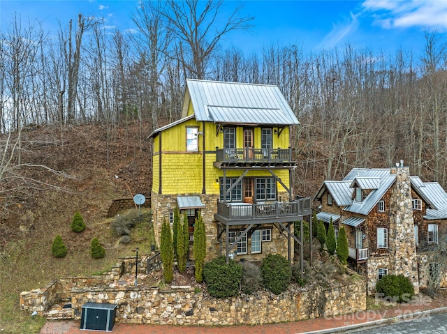 view of front of home with a balcony and central air condition unit