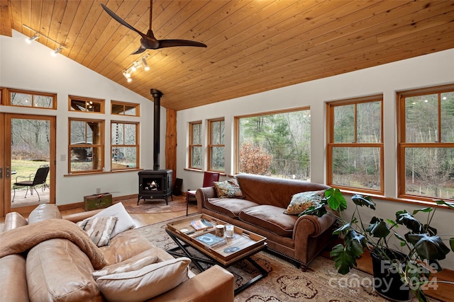 living room with a wood stove, ceiling fan, wooden ceiling, and vaulted ceiling