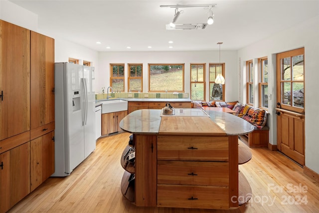 kitchen featuring a healthy amount of sunlight, white fridge with ice dispenser, and light hardwood / wood-style flooring