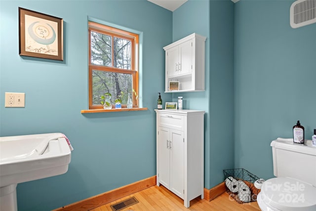 bathroom featuring hardwood / wood-style floors, toilet, and sink