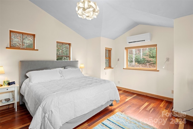 bedroom featuring an AC wall unit, multiple windows, vaulted ceiling, and hardwood / wood-style flooring