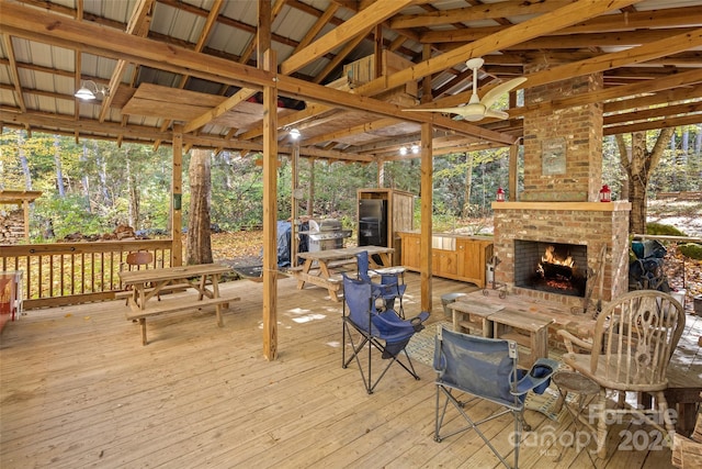 wooden deck with a gazebo and an outdoor brick fireplace