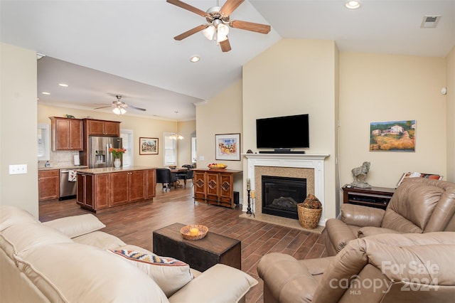 living room featuring dark hardwood / wood-style floors, ceiling fan with notable chandelier, and high vaulted ceiling