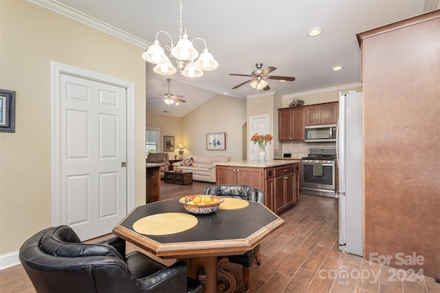 dining room featuring ceiling fan with notable chandelier, lofted ceiling, crown molding, and dark wood-type flooring