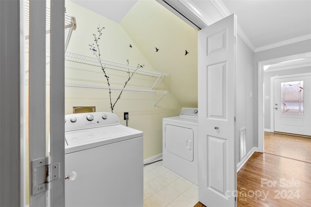 clothes washing area featuring washing machine and dryer and crown molding