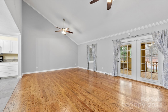 unfurnished living room with ceiling fan, french doors, vaulted ceiling, and light wood-type flooring