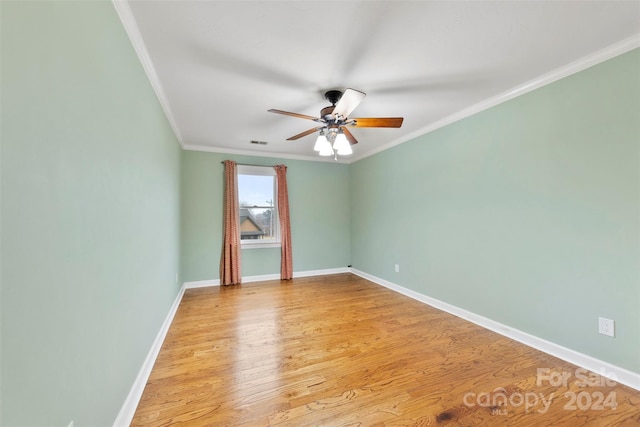 spare room featuring light wood-type flooring, ceiling fan, and crown molding