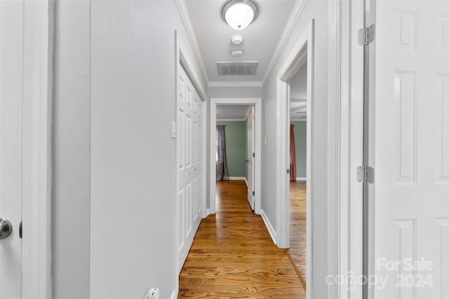 hall with crown molding and light hardwood / wood-style flooring