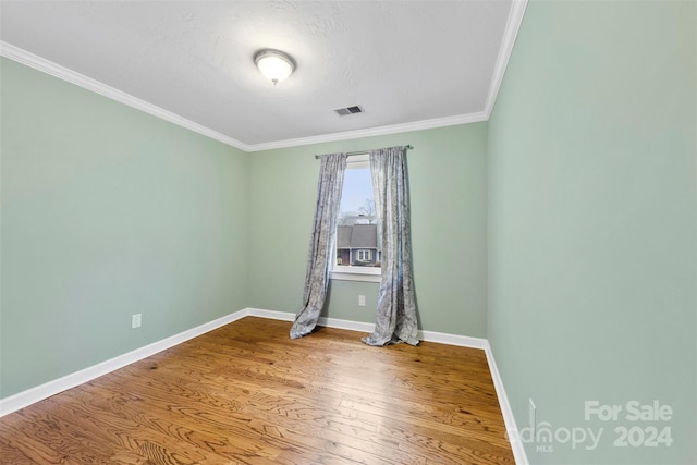 spare room with ornamental molding, a textured ceiling, and hardwood / wood-style flooring