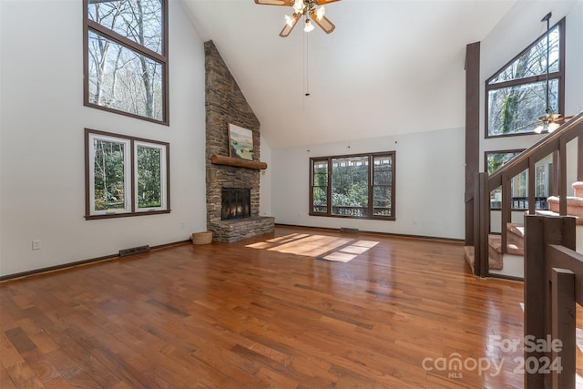 unfurnished living room with a wealth of natural light, high vaulted ceiling, and wood-type flooring