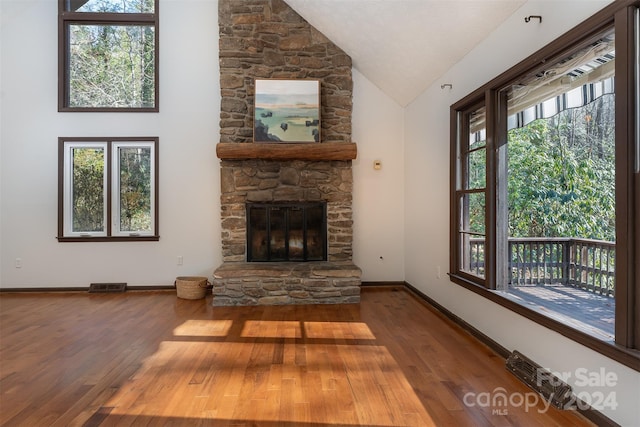 living room featuring a fireplace, high vaulted ceiling, a healthy amount of sunlight, and wood-type flooring