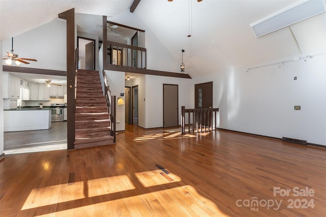 unfurnished living room with hardwood / wood-style flooring, sink, and high vaulted ceiling