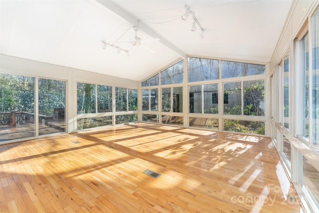 unfurnished sunroom featuring lofted ceiling with beams