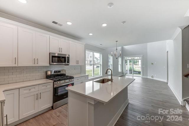 kitchen featuring sink, white cabinets, stainless steel appliances, and light wood-type flooring