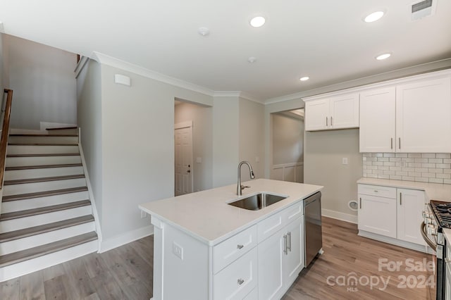 kitchen with stainless steel appliances, white cabinetry, a kitchen island with sink, and sink