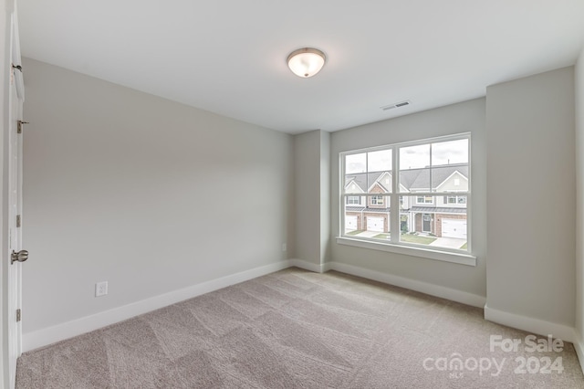 unfurnished room featuring light carpet