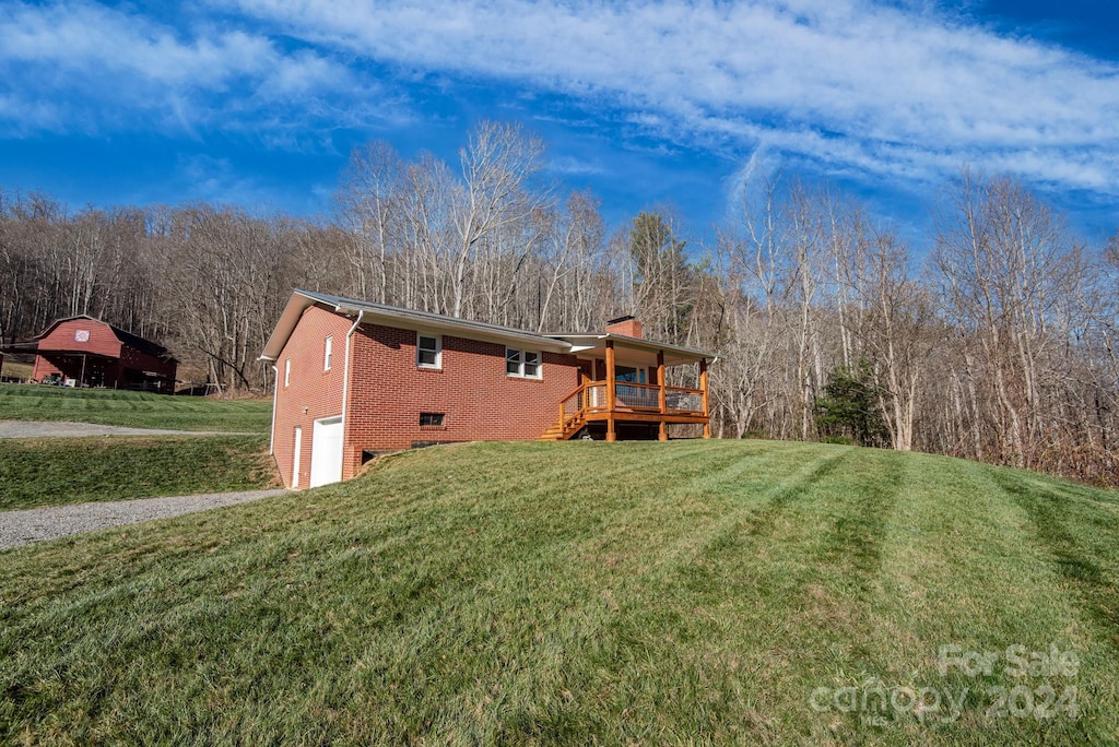 exterior space with a lawn, a wooden deck, and a garage