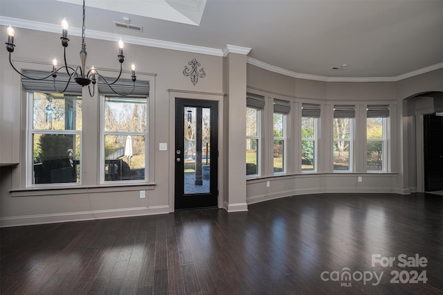 foyer featuring crown molding, dark hardwood / wood-style flooring, a healthy amount of sunlight, and an inviting chandelier