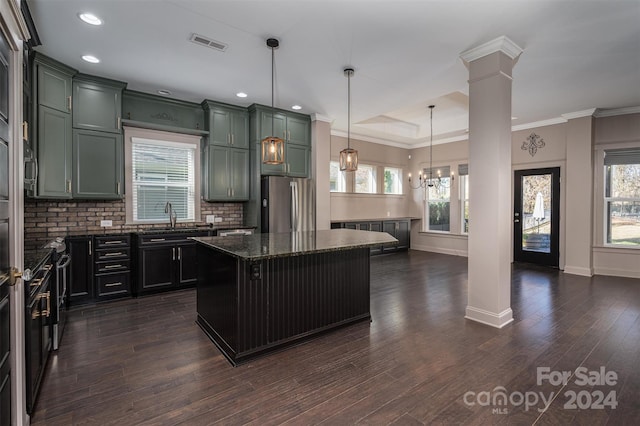 kitchen with plenty of natural light, a center island, stainless steel fridge, decorative light fixtures, and dark hardwood / wood-style flooring