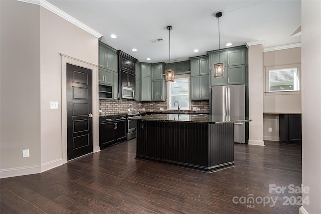 kitchen featuring dark wood-type flooring, crown molding, hanging light fixtures, a kitchen island, and stainless steel appliances