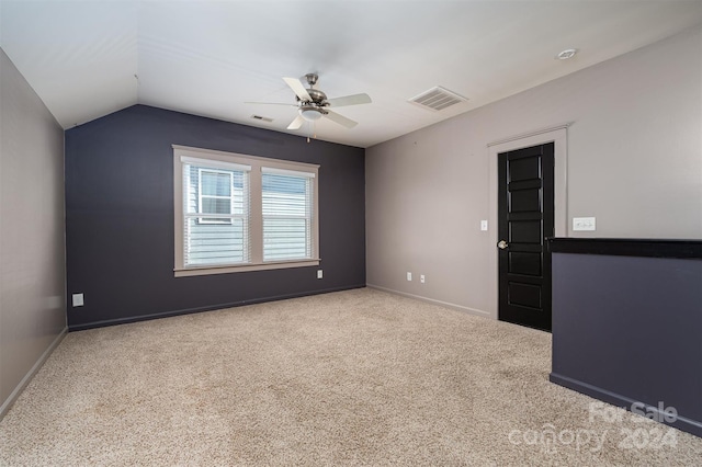 carpeted empty room featuring ceiling fan and lofted ceiling