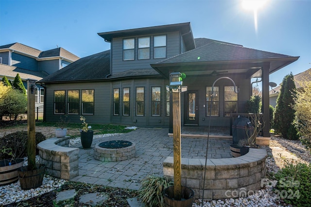 rear view of property featuring a patio and an outdoor fire pit