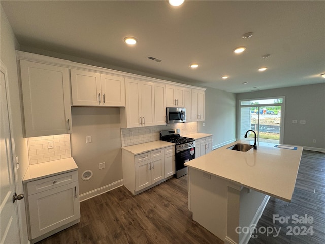 kitchen featuring a center island with sink, sink, appliances with stainless steel finishes, dark hardwood / wood-style flooring, and white cabinetry