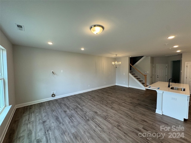 unfurnished room with an inviting chandelier, sink, and dark wood-type flooring