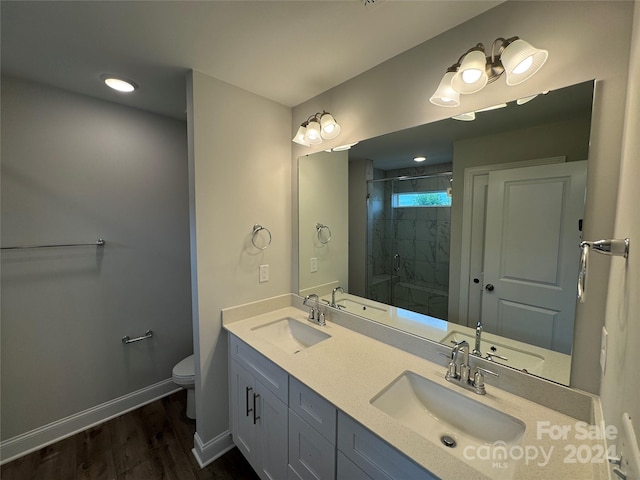 bathroom with hardwood / wood-style floors, vanity, toilet, and a shower with shower door