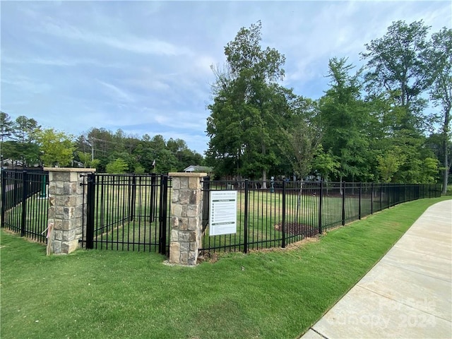 view of gate with a yard