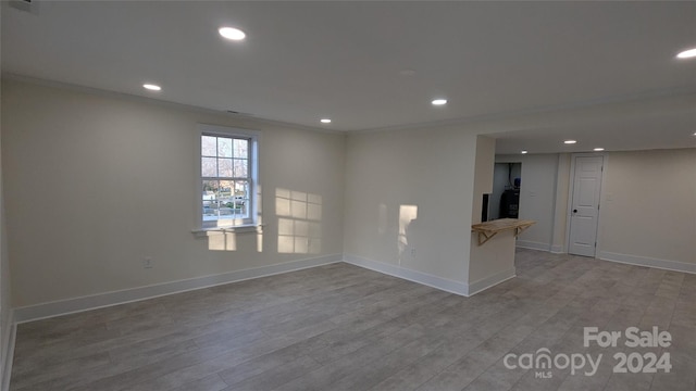 empty room featuring light hardwood / wood-style floors and ornamental molding