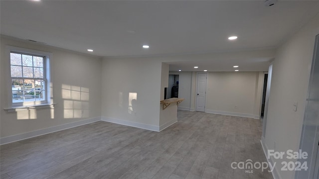 unfurnished room with light hardwood / wood-style floors and ornamental molding