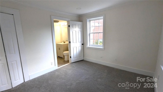 unfurnished bedroom featuring carpet flooring, crown molding, sink, and ensuite bath