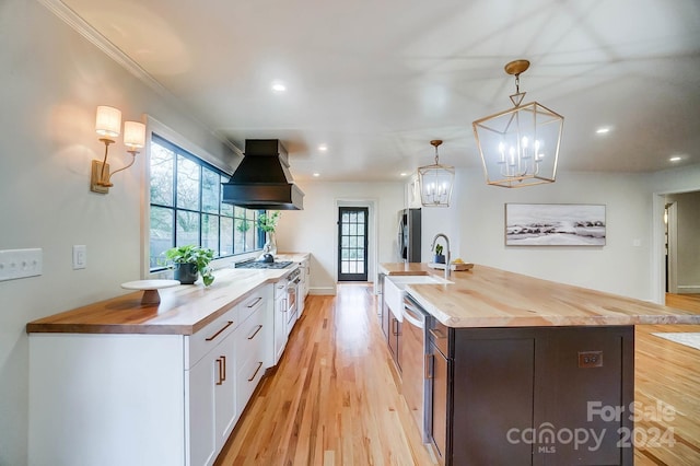 kitchen with white cabinetry, custom exhaust hood, light wood-type flooring, and wood counters