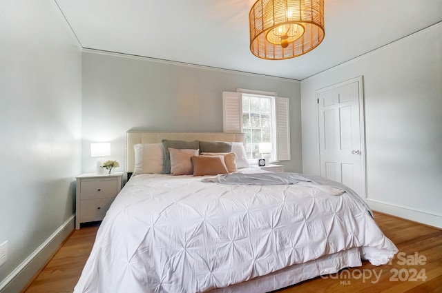 bedroom with hardwood / wood-style floors and ornamental molding