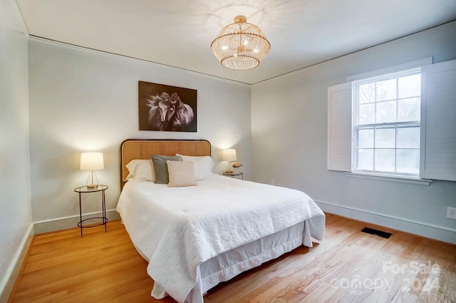 bedroom featuring a chandelier and hardwood / wood-style flooring