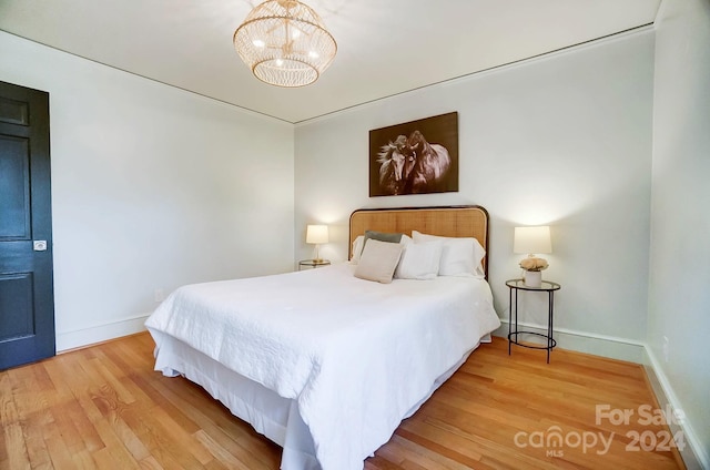 bedroom with a chandelier and hardwood / wood-style flooring